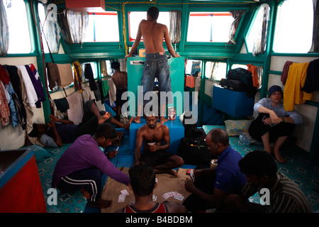 Writer Alain de Botton rests with resting crew after day's tuna fishing aboard a traditional dhoni fishing boat on Indian Ocean Stock Photo