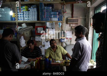 A crowded business dealing in cash from street customers buying sundries in a side street in Malé, Maldives Stock Photo