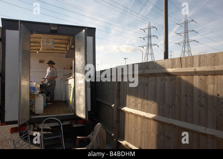 Pregnant lady serving fast-food in a mobile burger bar trailer in an overnight lorry park on the A126 in industrial Grays Stock Photo
