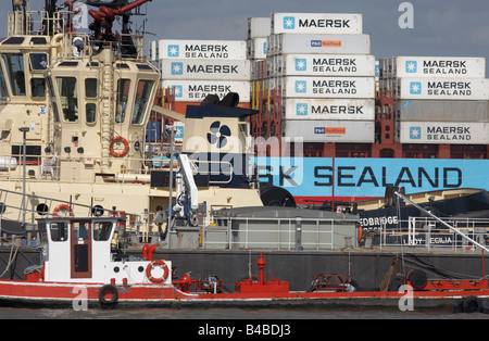 Assorted shipping on the River Thames: Container vessel in the background, two tugs, a floating gray pier and supply boat