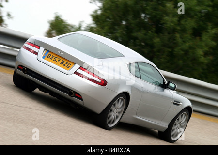 Car, Aston Martin DB9, roadster, model year 2003-, Coupe/coupe, silver, driving, moving, diagonal from the back, rear view, side Stock Photo