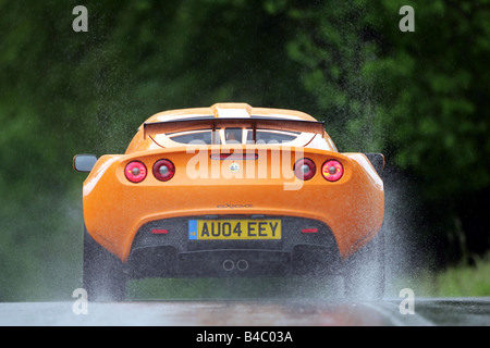 Car, Lotus Exige, model year 2004-, roadster, orange , coupe/Coupe, driving, rear view, country road, rain, wet highway, photogr Stock Photo