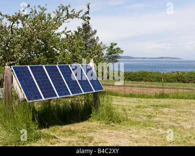 A set of solar panels located on an island provide a source of renewable energy. Stock Photo