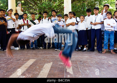 School children watch a break dancing and back flipping display in the band stand in the town square  Granada Nicaragua Stock Photo