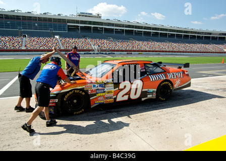 Pit crew looking under the hood of a race car at Lowe's Motor Speedway Stock Photo