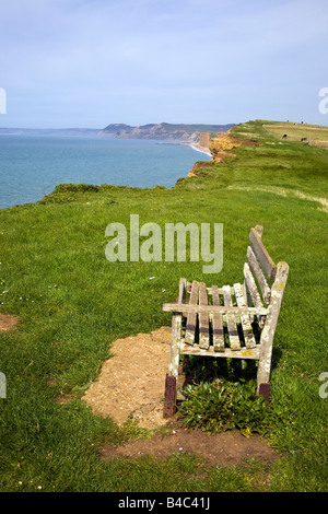 An empty wooden bench seat overlooking the sea near Burton Bradstock village in the spring time, Dorset, Great Britain UK 2008 Stock Photo