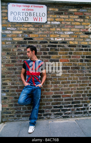Great Britain - London - Notting Hill district - Portobello Road - young man leaning against brick wall Stock Photo