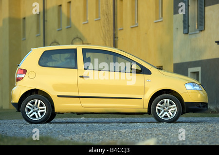 Car, VW Volkswagen Fox, model year 2005-, yellow, Miniapprox.s, Limousine, standing, upholding, side view, City, photographer: A Stock Photo