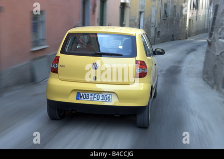 Car, VW Volkswagen Fox, model year 2005-, yellow, Miniapprox.s, Limousine, driving, diagonal from the back, rear view, City, pho Stock Photo