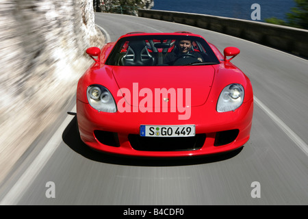 Car, Porsche Carrera GT, model year 2005-, red, Convertible, open top, driving, diagonal from the front, frontal view, country r Stock Photo