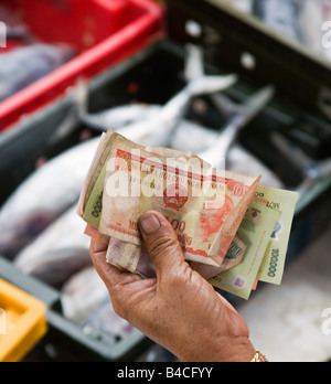 Handing over money at a fish market, Vietnam Stock Photo