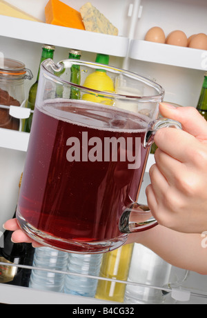 PUTTING JUG OF POMEGRANATE JUICE IN FRIDGE Stock Photo