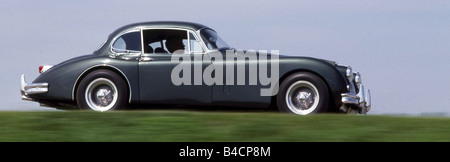 Jaguar XK 150 coupe, model year 1957-1961, anthracite, driving, side view, country road Stock Photo
