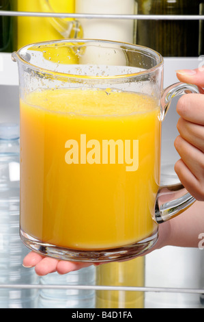 PUTTING JUG OF ORANGE JUICE IN FRIDGE Stock Photo