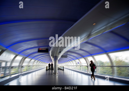 Air Travel England Manchester Airport blurred moving passengers on connecting walkway Stock Photo