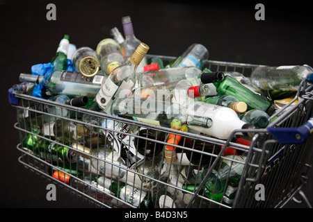 A supermarket trolley full of empty drinks bottles and cans awaiting collection on the pavement outside a flat in Birmingham. Stock Photo