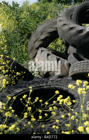 old tractor tyres left in field in countryside Stock Photo