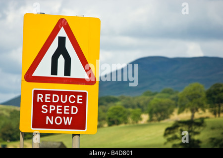 Road sign warning sign of dual carriageway ending speed reduction, roads merge advised, England UK Stock Photo