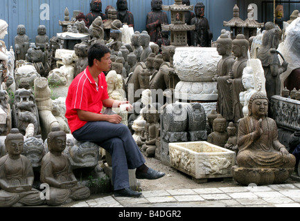 A statue seller in Panjiayuan Flea Market, Beijing, China Stock Photo