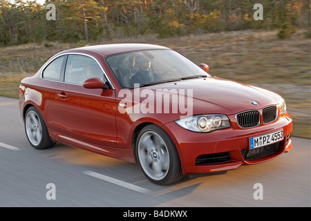 BMW 135i Coupe, driving, diagonal from the front, frontal view, country road, red, model year 2007- Stock Photo