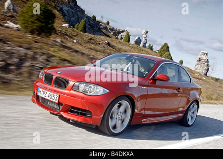 BMW 135i Coupe, driving, diagonal from the front, frontal view, country road, red, model year 2007- Stock Photo