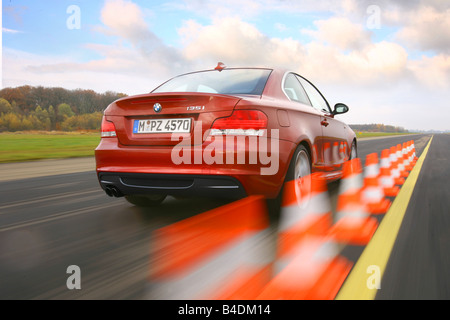 BMW 135i Coupe, driving, diagonal from the back, rear view, Pilonen, test track, verwischt, red, model year 2007- Stock Photo