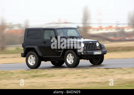 Jeep Wrangler Rubicon 3.8, model year 2008-, black, driving, diagonal from the front, frontal view, side view, country road Stock Photo