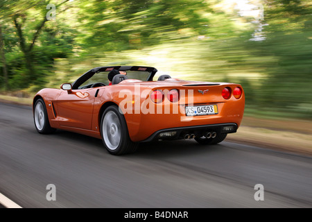 Corvette C6, rust-red model year 2008, orange -metallic, driving, diagonal from the back, rear view, country road, open top Stock Photo