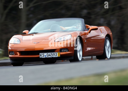 Corvette C6, rust-red model year 2008, orange -metallic, driving, diagonal from the front, frontal view, country road, open top Stock Photo