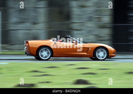 Corvette C6, rust-red model year 2008, orange -metallic, driving, side view, country road, open top Stock Photo