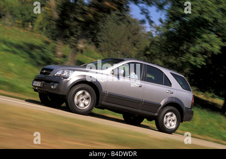 Car, Kia Sorento, cross country vehicle, model year 2002-, silver, driving, country road, diagonal from the front, side view Stock Photo