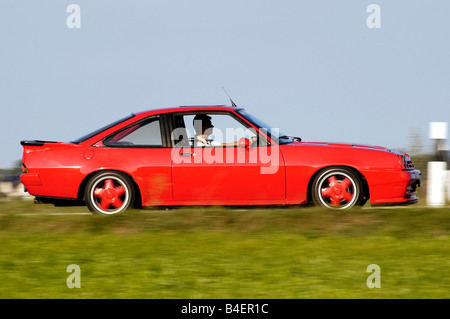 Car, Opel Manta B, model year 1983, red, Coupé, Coupe, old car, 1980s, eighties, driving, side view, road, country road, photogr Stock Photo