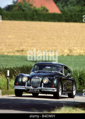 Jaguar XK 150 Coupé, model year 1957-1961, dark grey, driving, diagonal front, front view, road, country road Stock Photo