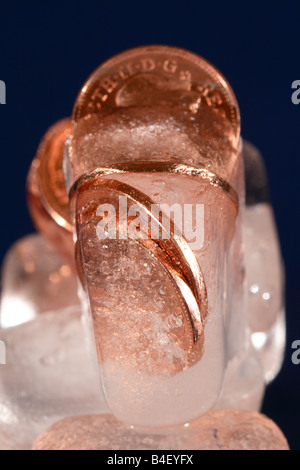 Frozen assets coin money cash in ice block financial freeze concept Stock Photo