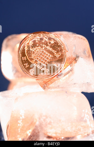 Frozen assets coin money cash in ice block financial freeze concept Stock Photo