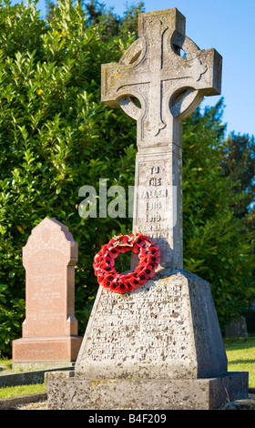 A typical stone war memorial with Celtic cross and poppy wreath taken in the Wiltshire village of All Cannings, England, UK Stock Photo