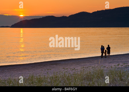 People walking along the beach at Agawa Bay at sunset, Lake Superior, Lake Superior Provincial Park, Ontario, Canada Stock Photo