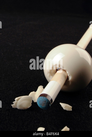 A surrealistic composition of a cue stick smashing through a cue ball. Stock Photo