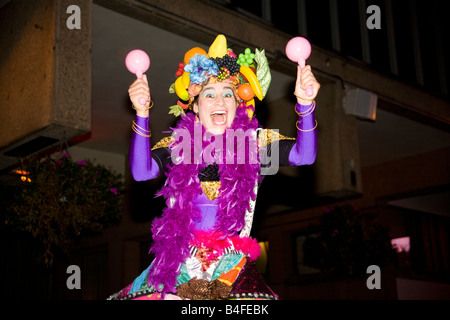 A joyful carnival entertainer helps the crowds have fun at a street carnival. Stock Photo