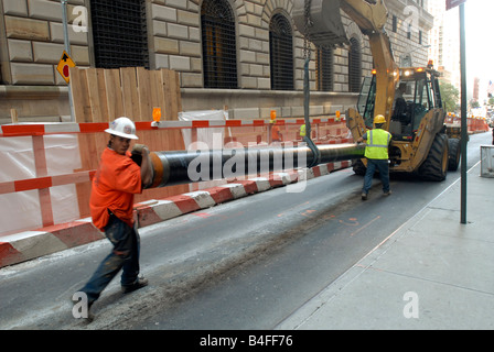 Workers move a heavy pipe down Liberty Street in New York Richard B Levine Stock Photo