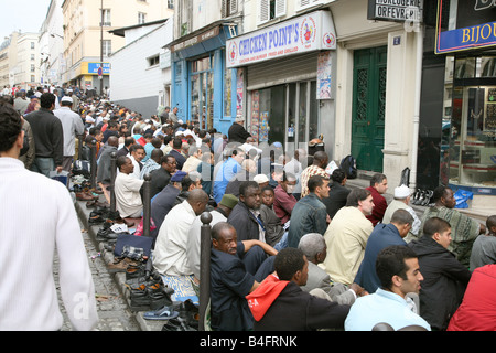 The Boulevard of the Barbes, Paris, France, Muslims prey on the street outside the Mosque. Stock Photo