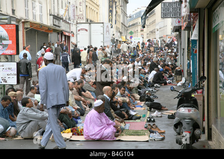 The Boulevard of the Barbes, Paris, France, Muslims prey on the street outside the Mosque. Stock Photo