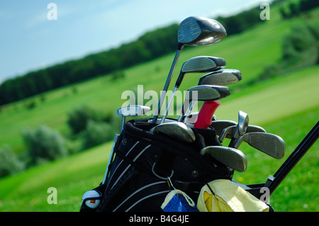 a golf caddy bag full of golf club with green grass golf course in the background  out of focus- France Stock Photo