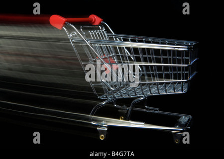 A miniature empty shopping cart moving, blurred motion Stock Photo