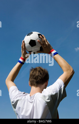 A soccer player throwing a soccer ball Stock Photo