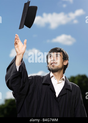 A male graduate throwing his mortar board in the air Stock Photo