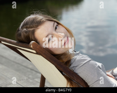 A young woman sitting in a deck chair Stock Photo