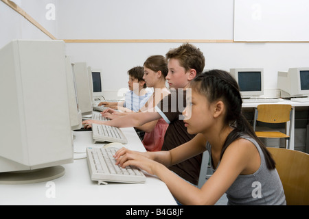 Four pre-adolescent children in a computer lab Stock Photo
