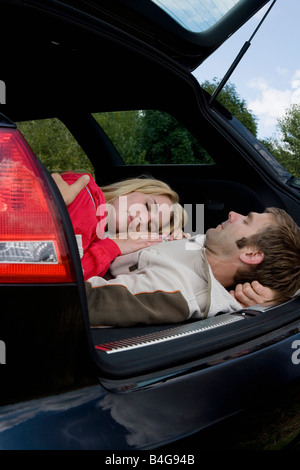 A couple sleeping in the back of a car Stock Photo