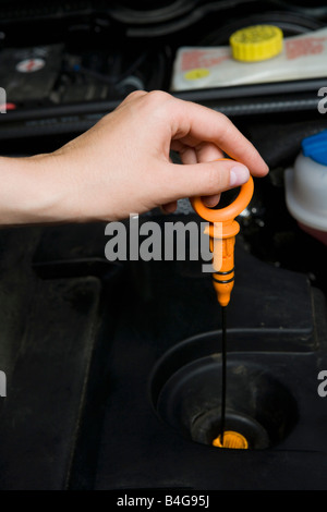 A person checking the oil in a car engine Stock Photo